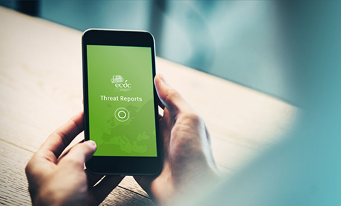 Person holding a mobile device with the ECDC Threat Reports App open
